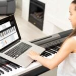 little girl play piano in class education with laptop in home online learning in covid-19 crisis quarantine.